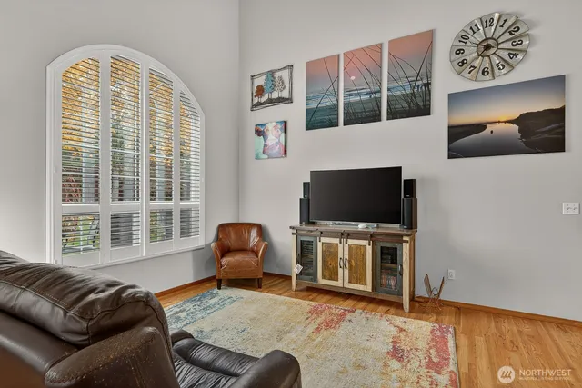 a living room with furniture a flat screen tv and a large window
