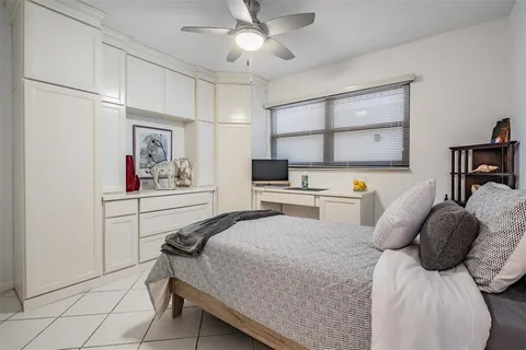 a bedroom with a bed a large window and wall painting