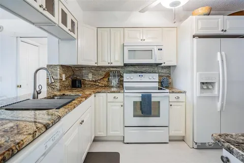 a kitchen with white cabinets and white appliances