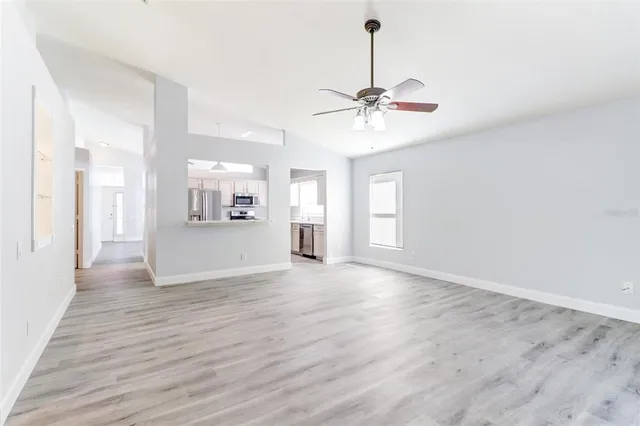 a view of an empty room with window and wooden floor