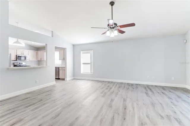a view of empty room with wooden floor and window