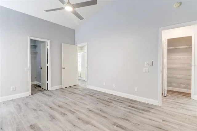 an empty room with wooden floor and closet area