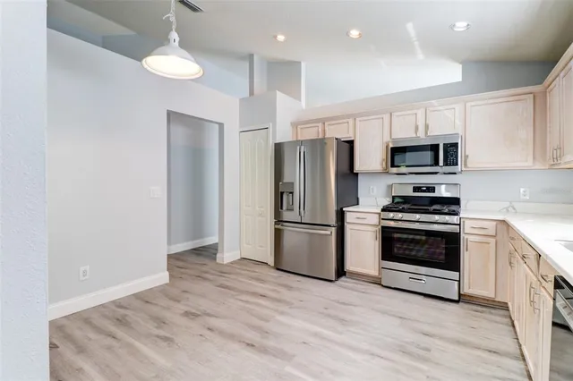 a kitchen with a refrigerator and a stove top oven