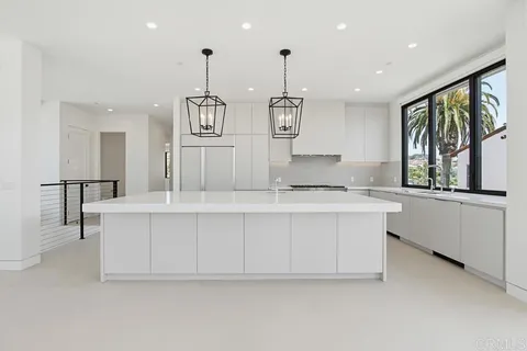 a kitchen with stainless steel appliances granite countertop a stove and a large window