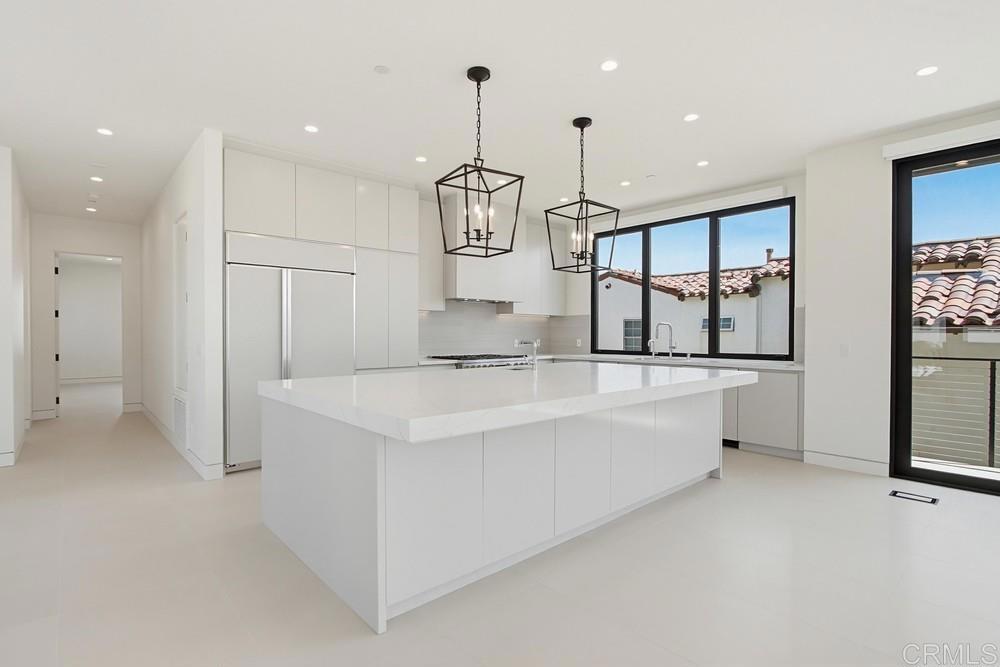 206 4th Street Encinitas, CA 92024 - Photo 17 of 64 a large kitchen with kitchen island a large counter top appliances and a ceiling fan