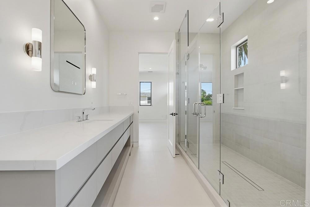 206 4th Street Encinitas, CA 92024 - Photo 32 of 64 a bathroom with a double vanity sink a toilet and shower