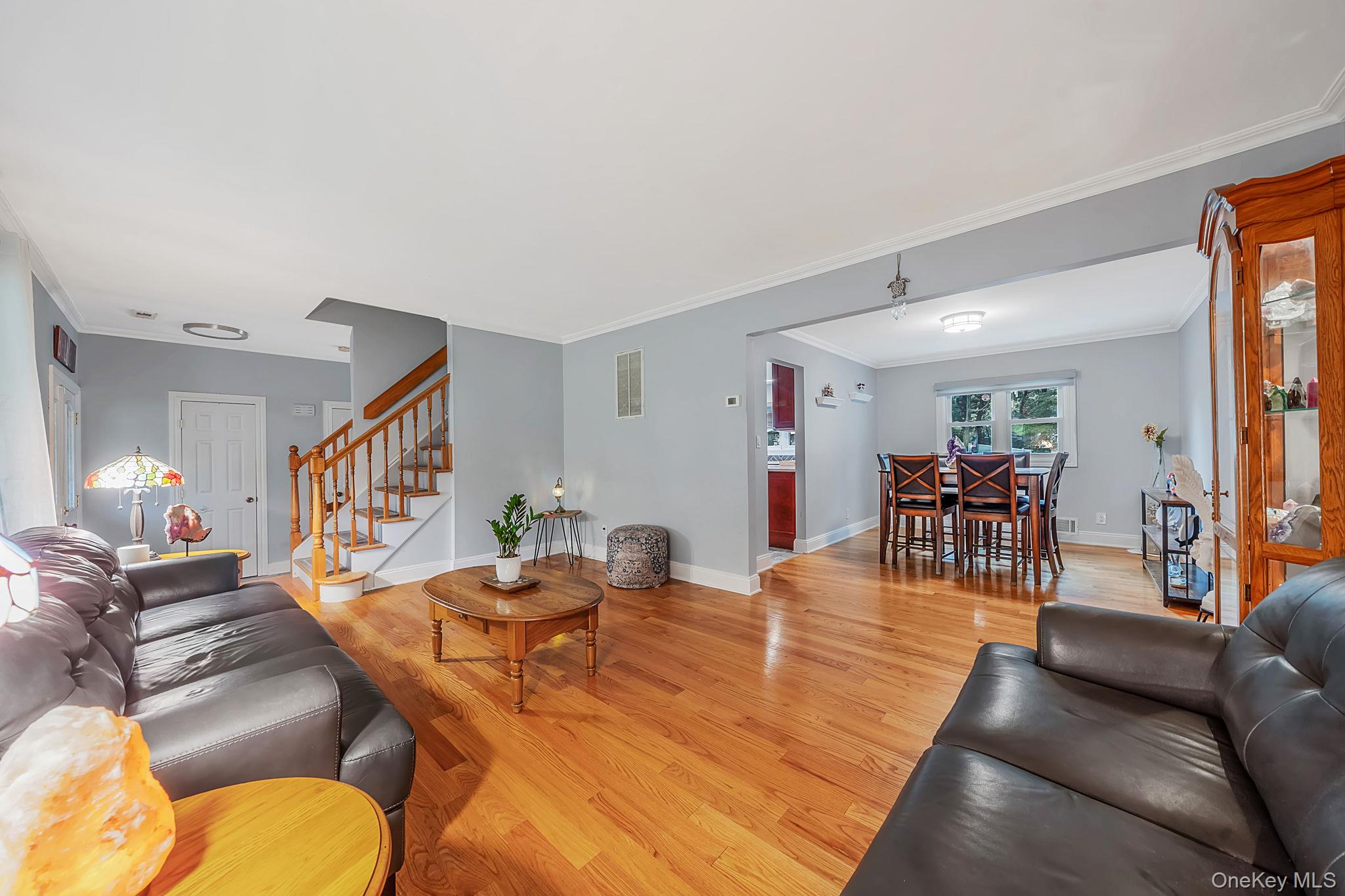 5 Rockhill Road Rocky Point, NY 11778 - Photo 5 of 48 Expansive living area featuring hardwood flooring, light gray wall paint, and white crown molding