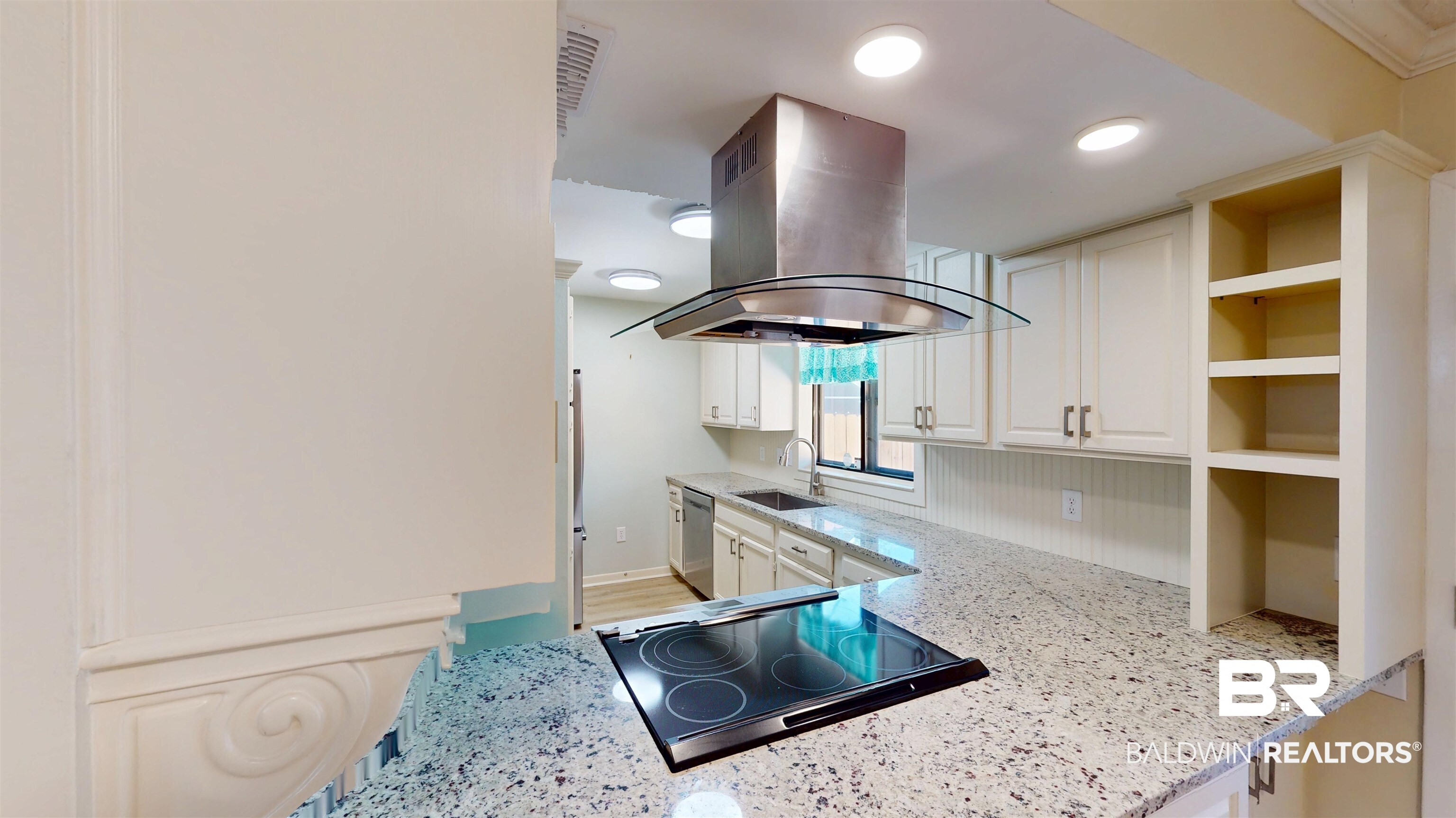 2901 Grant Street, Unit 902 Mobile, AL 36606 - Photo 8 of 35 Kitchen featuring light stone countertops, open shelves, island range hood, white cabinets, and black electric cooktop