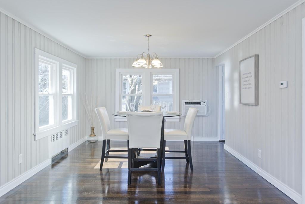 90 Darling Street Springfield, MA 01151 - Photo 18 of 42 a dining room with wooden floor a chandelier a glass table and chairs