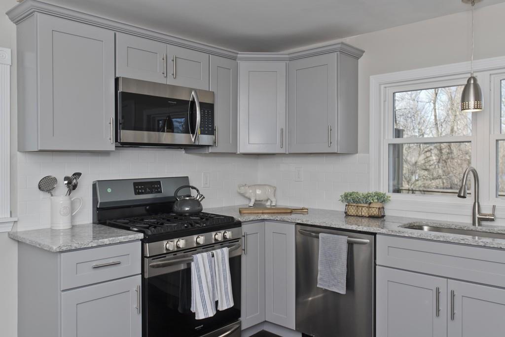 90 Darling Street Springfield, MA 01151 - Photo 3 of 42 a kitchen with stainless steel appliances granite countertop white cabinets a stove a sink and a microwave