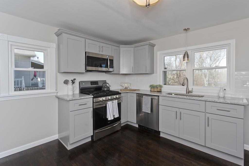 90 Darling Street Springfield, MA 01151 - Photo 4 of 42 a kitchen with granite countertop white cabinets a sink a window and stainless steel appliances