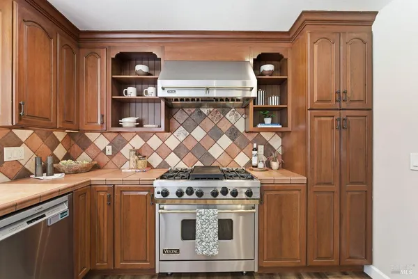 a large kitchen with stainless steel appliances granite countertop a stove and a sink