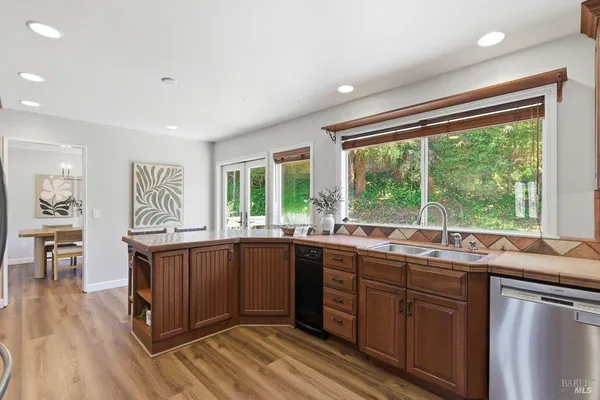 a kitchen with stainless steel appliances a refrigerator and wooden floor