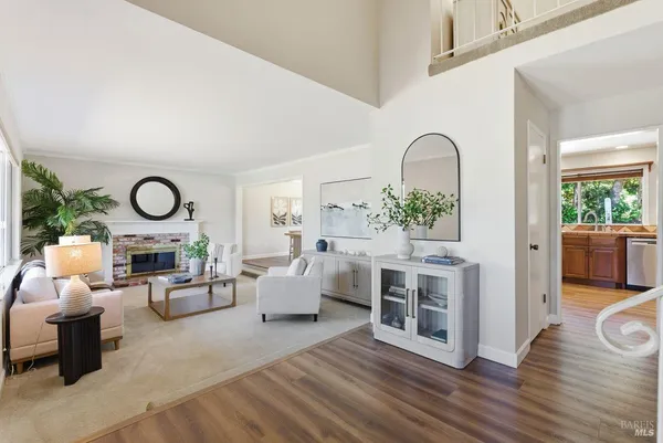 a living room with furniture large window and wooden floor