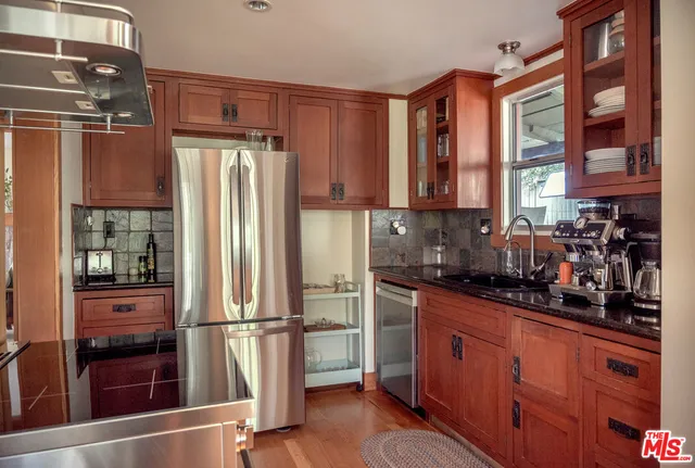 a kitchen with stainless steel appliances granite countertop a refrigerator and a sink