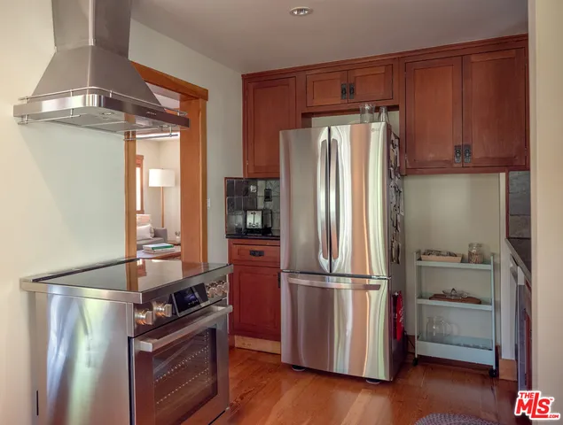 a kitchen with a refrigerator and a wooden floor