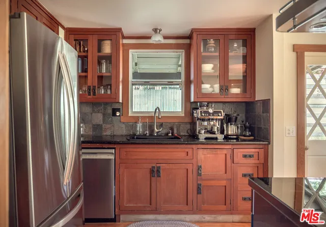a kitchen with granite countertop a refrigerator and a sink