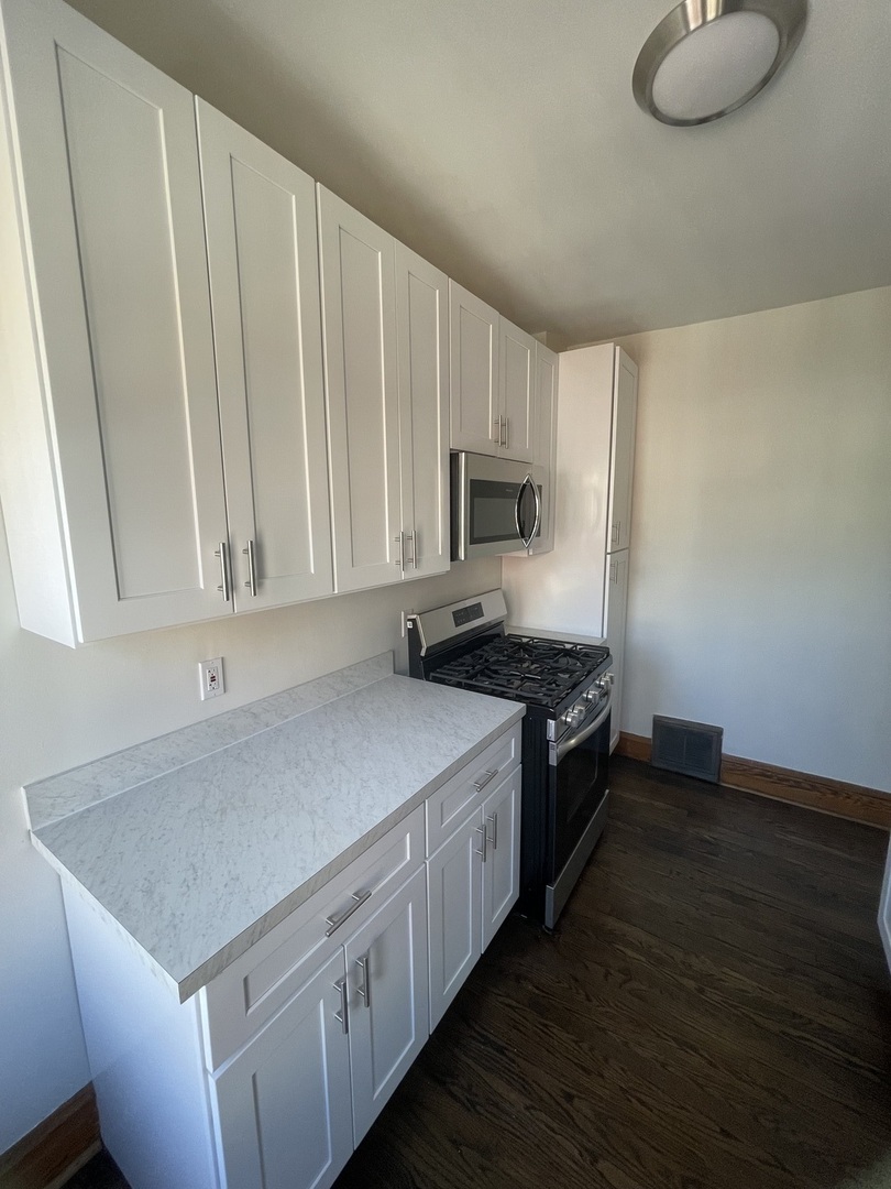 115 North Myrtle Avenue, Unit 2F Elmhurst, IL 60126 - Photo 8 of 14 a kitchen with a stove cabinets and a wooden floor
