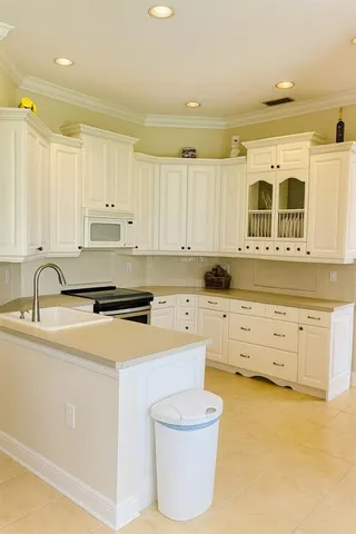 a kitchen with white cabinets and sink