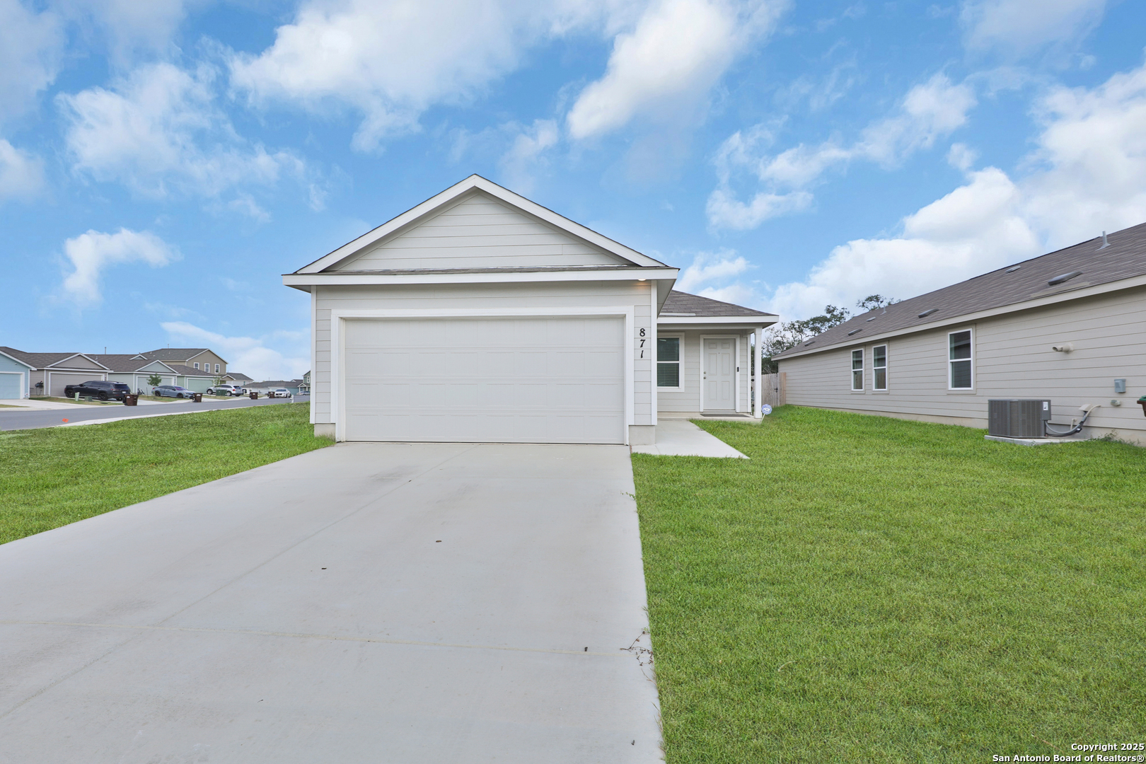 a view of a white house next to a yard with big trees