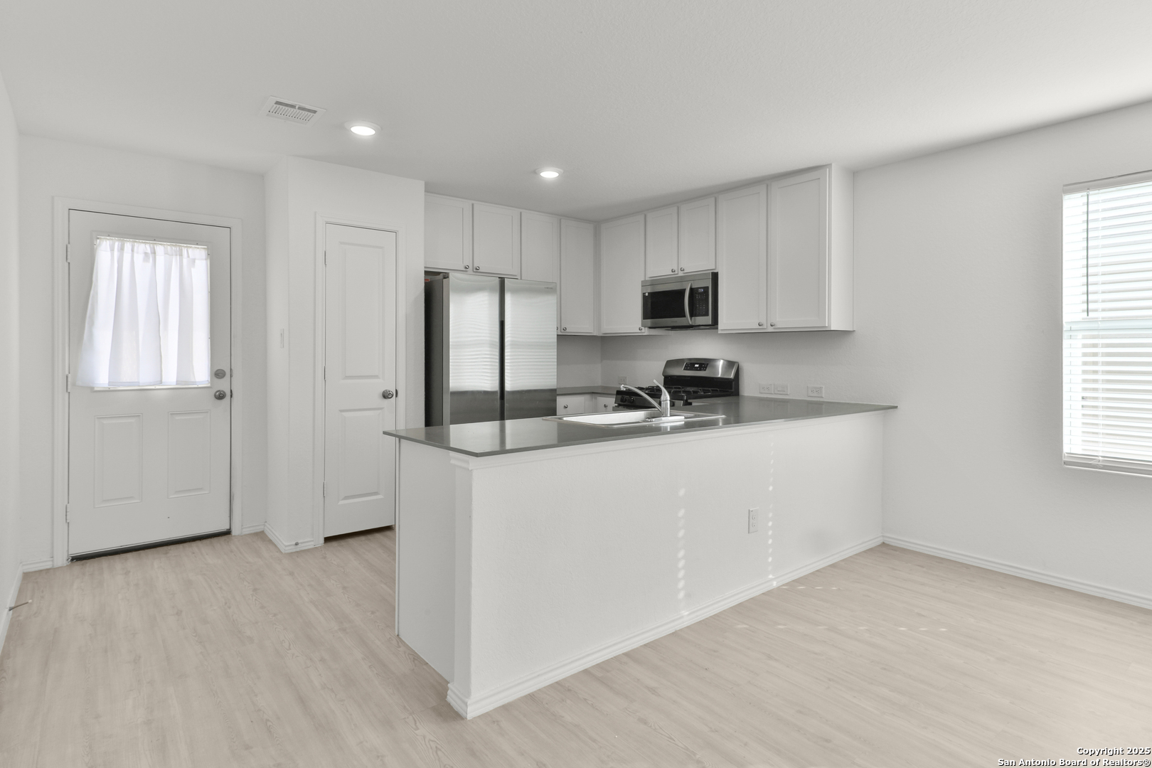 871 Landon Ridge San Antonio, TX 78253 - Photo 8 of 23 a kitchen with stainless steel appliances a refrigerator a sink a stove a microwave and cabinets