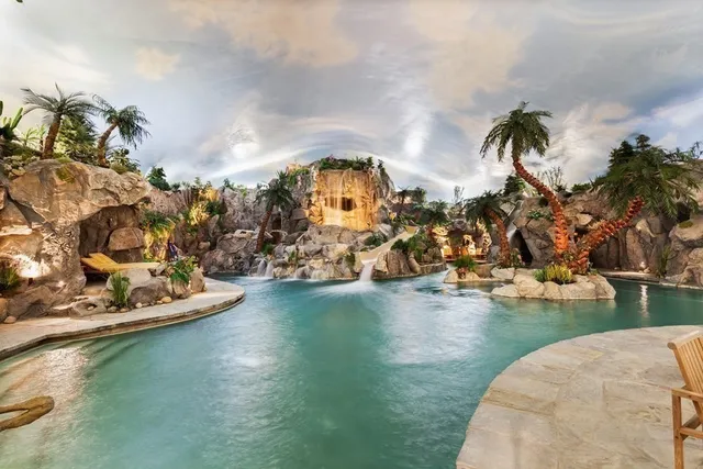 a very nice looking dining room with kitchen island furniture a large window and a chandelier