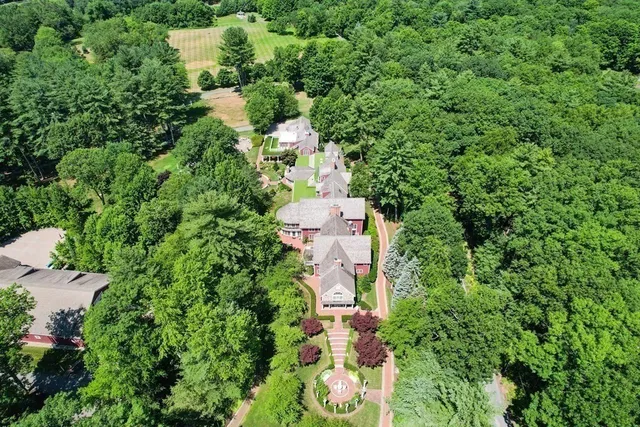 an aerial view of residential house with outdoor space and trees all around