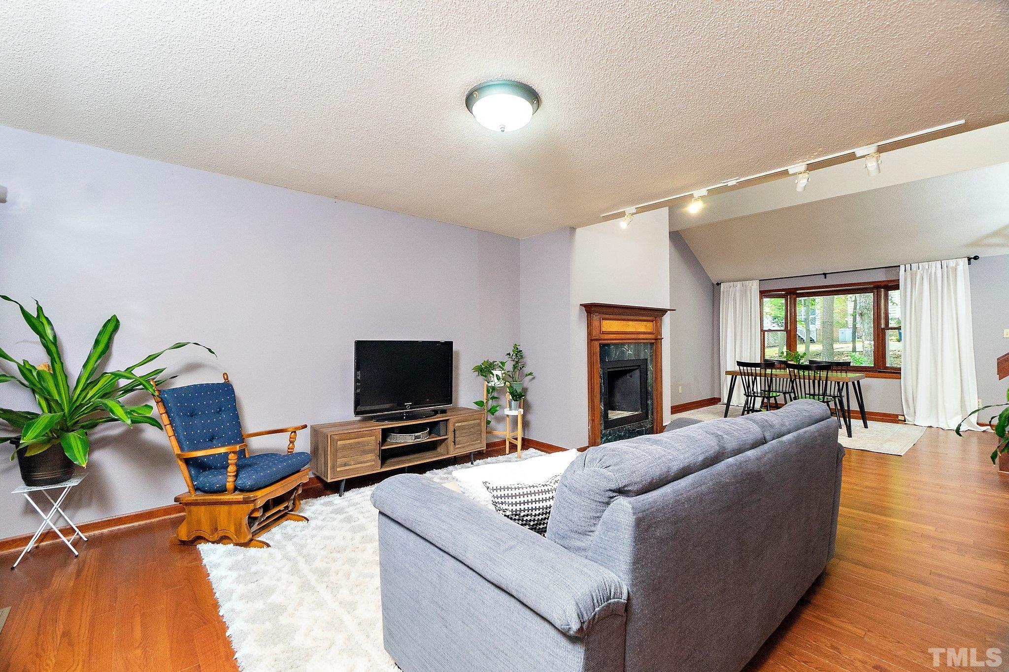 7838 Breckon Way Raleigh, NC 27615 - Photo 5 of 30 a living room with furniture and a flat screen tv
