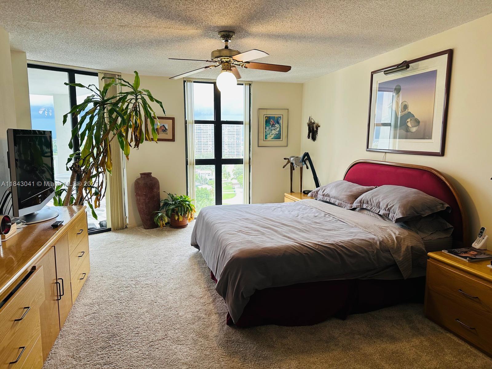 4000 Towerside Terrace, Unit 1503 Miami, FL 33138 - Photo 14 of 23 a spacious bedroom with a bed and a chandelier