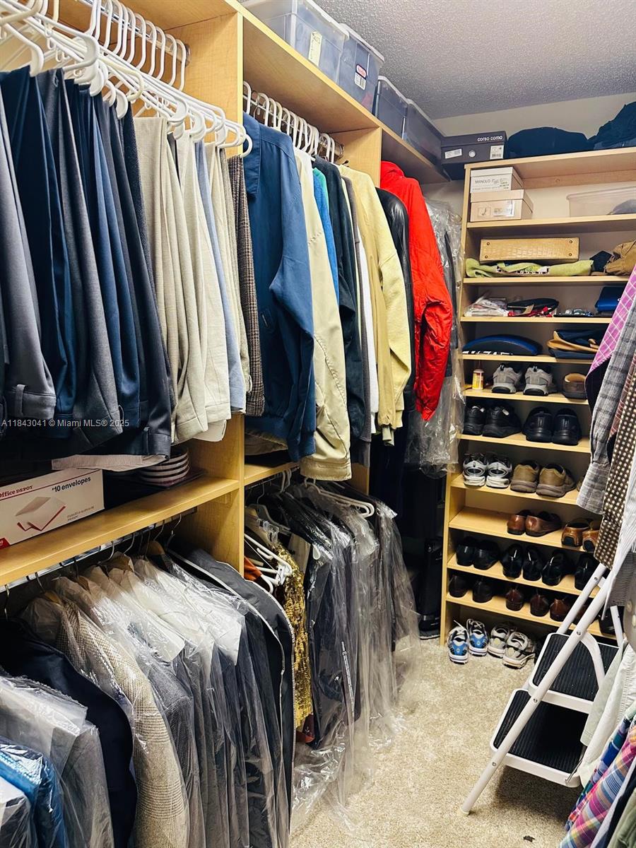 4000 Towerside Terrace, Unit 1503 Miami, FL 33138 - Photo 19 of 23 a view of walk in closet with clothes and shoes