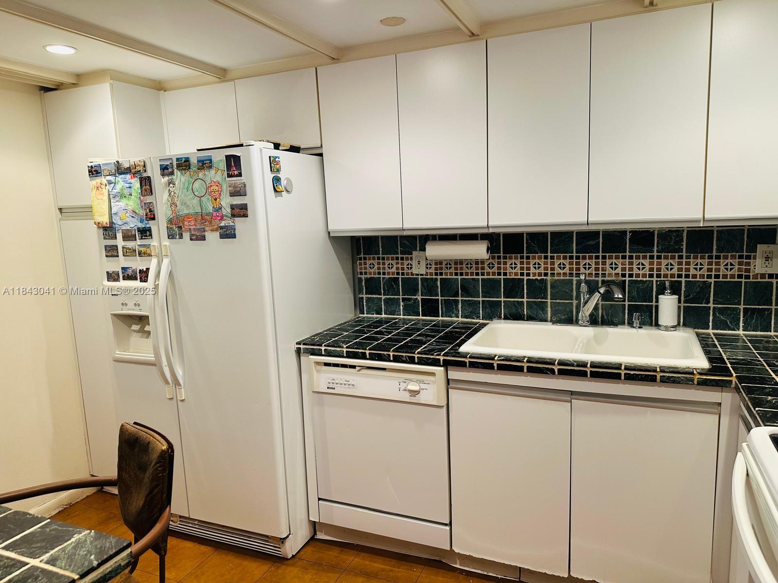 4000 Towerside Terrace, Unit 1503 Miami, FL 33138 - Photo 4 of 23 a kitchen with granite countertop cabinets and white appliances