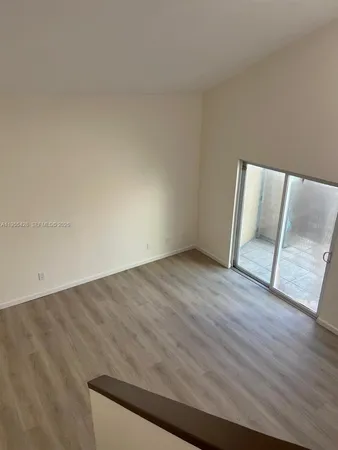an empty room with wooden floor and door