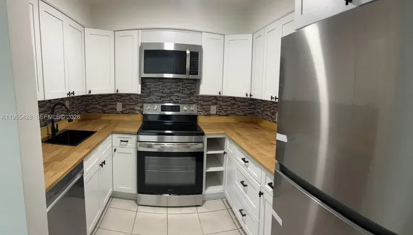 a kitchen with stainless steel appliances granite countertop a stove and a microwave