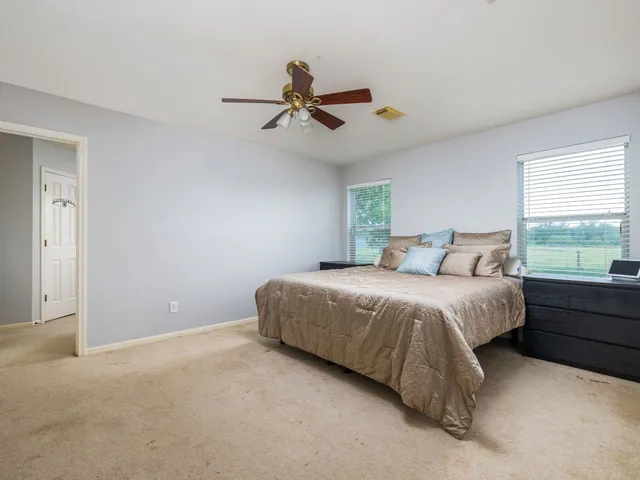 a spacious bedroom with a bed and large windows