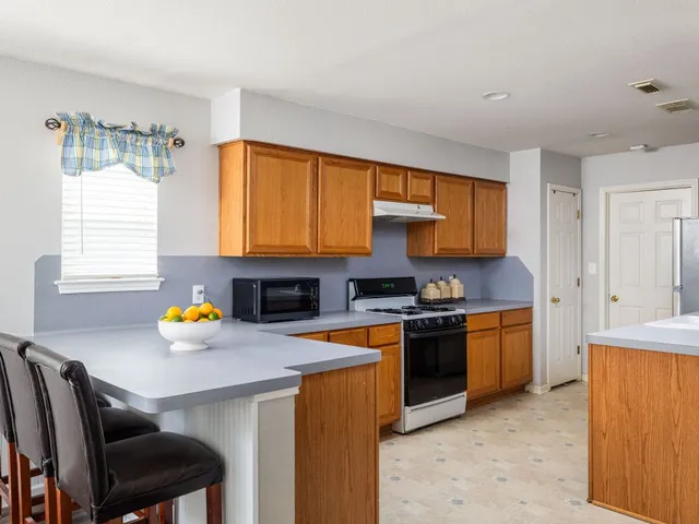 a kitchen with stainless steel appliances a stove a sink and a refrigerator