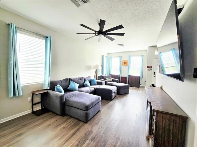 a kitchen with stainless steel appliances kitchen island granite countertop a stove top oven a sink dishwasher a refrigerator and a microwave oven with wooden floor