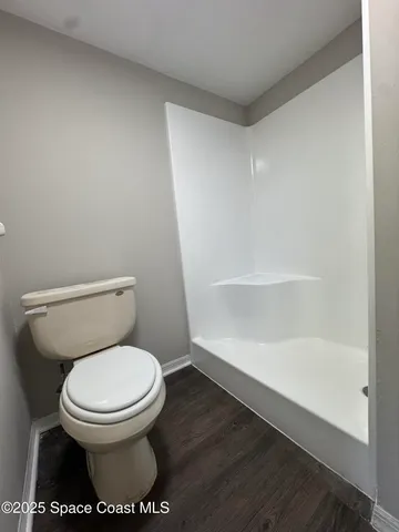 a white toilet sitting next to a shower