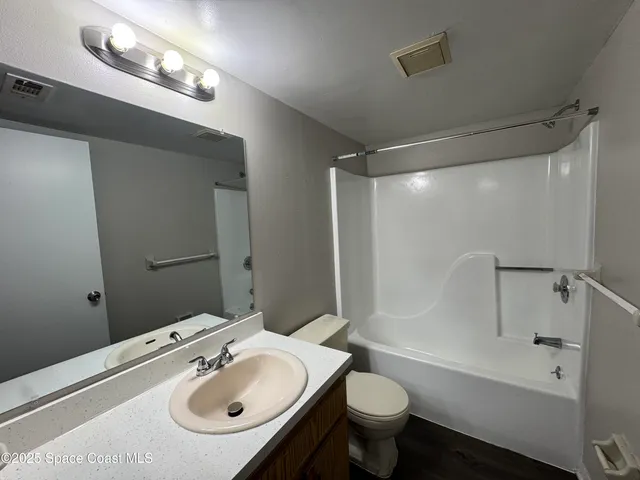 a bathroom with a sink mirror vanity and toilet
