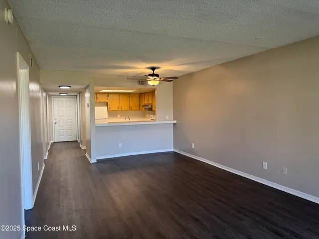 a view of a room with wooden floor and a window
