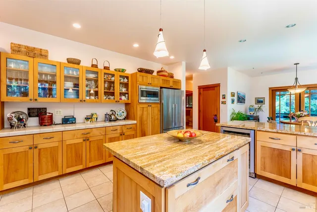 a kitchen with a stove a sink a counter top space and living room view