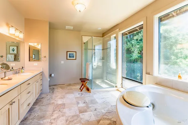 a spacious bathroom with a tub sink and mirror