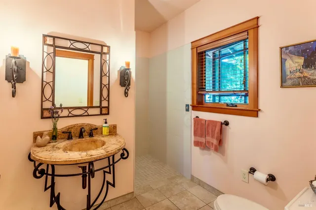a bathroom with a sink a vanity and a large mirror