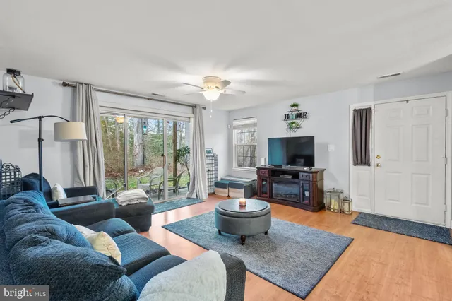 a living room with furniture a flat screen tv and a large window