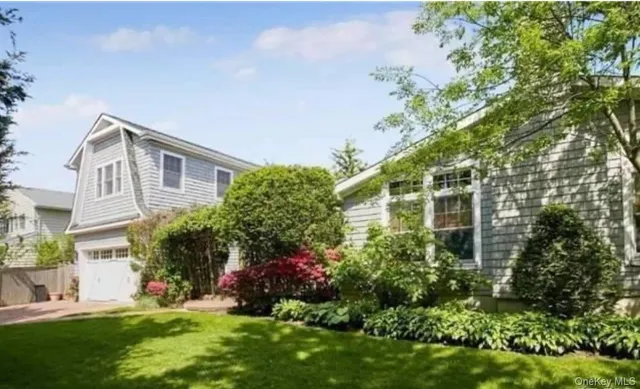 a front view of a house with a garden and plants