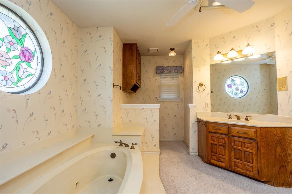 714 Mill Creek Road Lancaster, TX 75146 - Photo 15 of 27 Master bath features jetted tub, split vanities, marble type flooring around wet areas, and stain glass window.