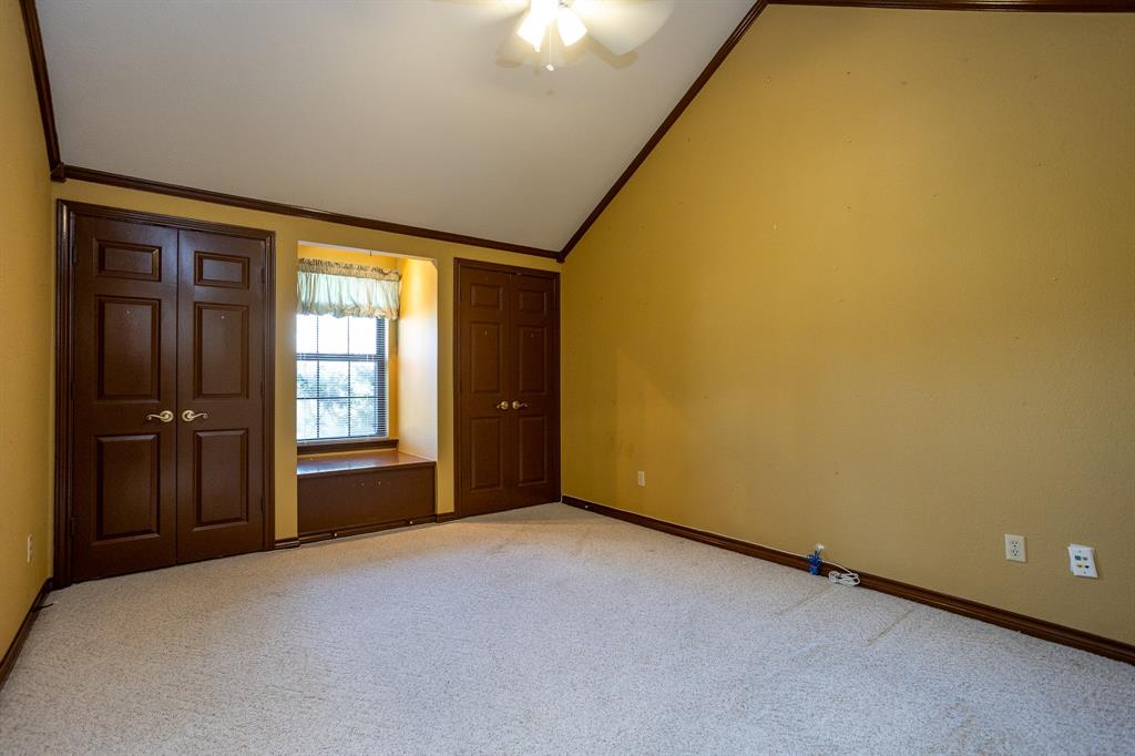 714 Mill Creek Road Lancaster, TX 75146 - Photo 19 of 27 Middle bedroom has vaulted ceilings, 2 closets and window seat with type carpetand ceiling fan..