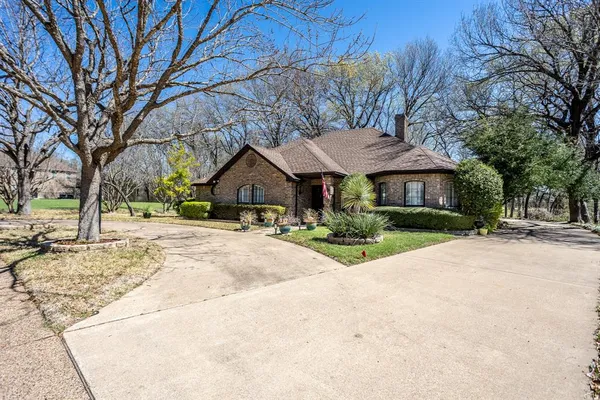 a front view of a house with a yard and trees