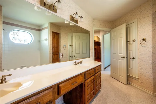 a spacious bathroom with a granite countertop sink and a mirror