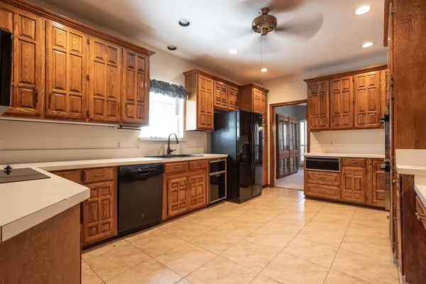 a kitchen with stainless steel appliances granite countertop a refrigerator a sink dishwasher a stove with wooden cabinets and floor