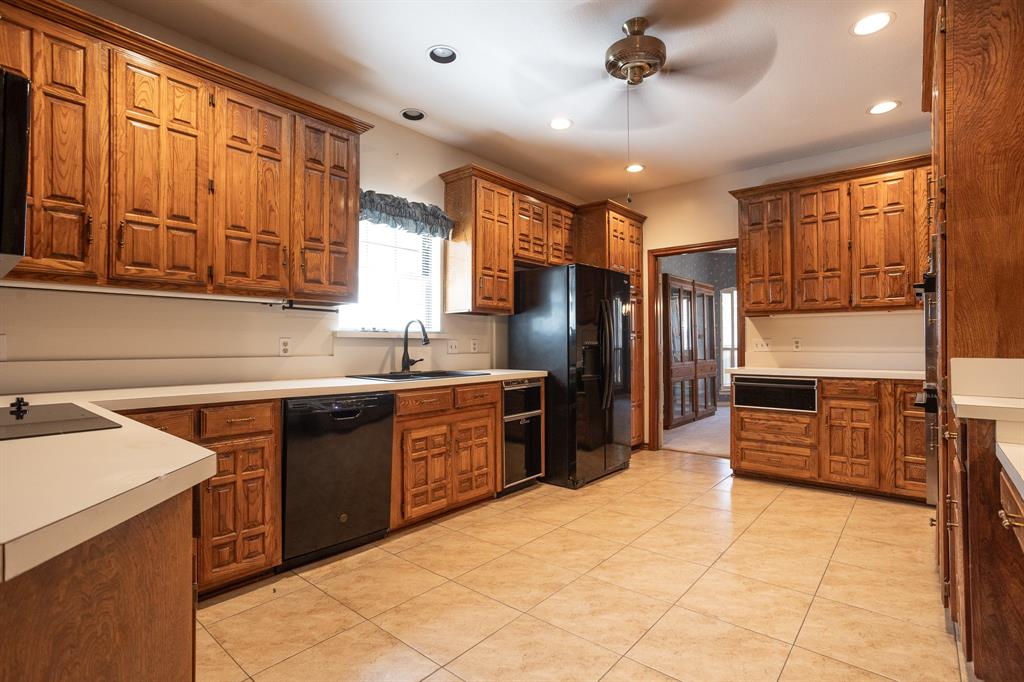 714 Mill Creek Road Lancaster, TX 75146 - Photo 8 of 27 Kitchen has dishwasher, metal sink, trash compactor and refrigerator remain. Cabinets are custom with many extra like pull out shelves, cabinets designed to hold cookie sheets, pantry with storage on the back of doors.